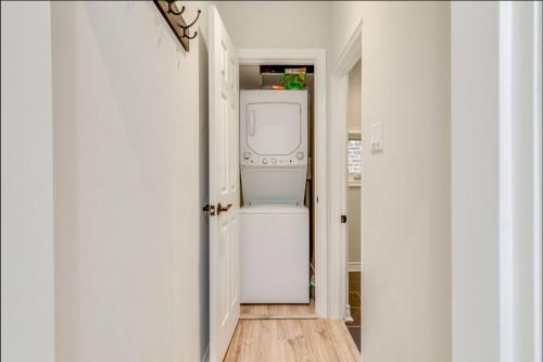 a hallway with a washer and dryer in a house at Casa Leslieville - 2BR Suite with LRG Patio in Toronto