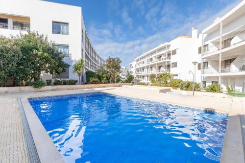 an empty swimming pool in front of two apartment buildings at Apartment Perola-superb Base In Historical Centre in Tavira