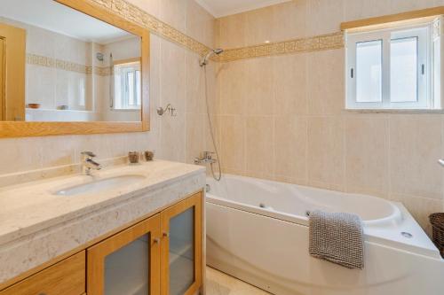 a bathroom with a tub and a sink and a bath tub at Enes Retreat - By Y Concept in Setúbal