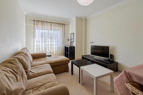 a living room with a couch and a tv at Enes Retreat - By Y Concept in Setúbal