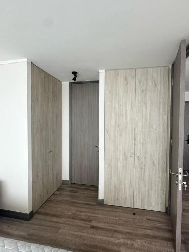 an empty room with wooden doors and wooden floors at Depto privado con vista despejada al mar en 1 línea, terraza 20 mts y estacionamiento con acceso desde el borde costero in Vina del Mar