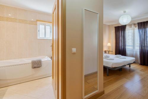 a bathroom with a bath tub and a table with a table at Enes Retreat - By Y Concept in Setúbal