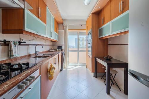 a kitchen with wooden cabinets and a sink and a table at Enes Retreat - By Y Concept in Setúbal