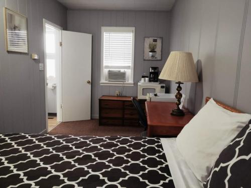 a bedroom with a bed and a desk and a window at Melsask Motel in Melville