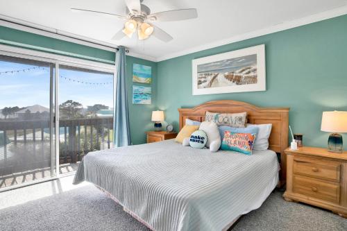 a bedroom with a bed and a balcony at TB Beach House in Dauphin Island
