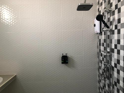 a bathroom with a shower with black and white tiles at Suksabai Raiwan and Pool Villa in Jomtien Beach