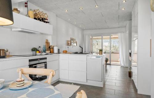 a kitchen with white cabinets and a table at Cozy Apartment In Lemvig With Sauna in Lemvig