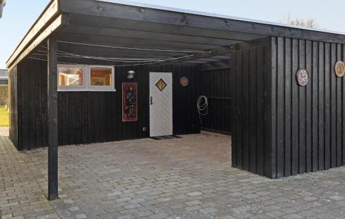 a black building with a white door and a white door at 2 Bedroom Amazing Home In Skibby in Skibby