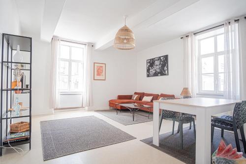 un salon avec une table et un canapé dans l'établissement Elegant & Spacious Apartment - Steps from Cathedral, à Reims