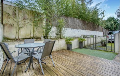 eine Terrasse mit einem Tisch und Stühlen auf einer Holzterrasse in der Unterkunft Charmante Maison Proche Plage in Royan
