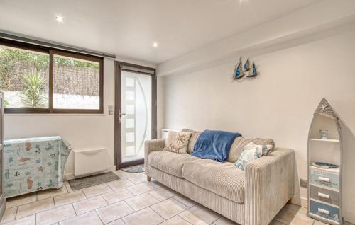 ein Wohnzimmer mit einer Couch und einem Fenster in der Unterkunft Charmante Maison Proche Plage in Royan