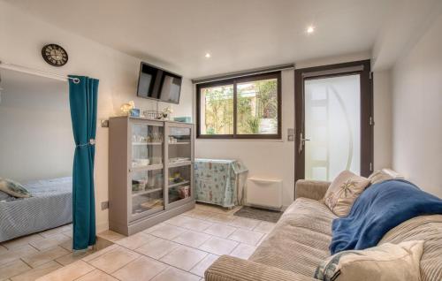 un salon avec un canapé et une télévision dans l'établissement Charmante Maison Proche Plage, à Royan
