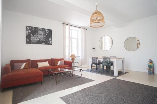 un salon avec un canapé rouge et une table dans l'établissement Elegant & Spacious Apartment - Steps from Cathedral, à Reims