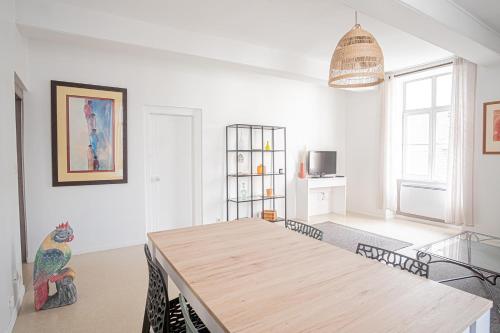 une salle à manger avec une table et des chaises en bois dans l'établissement Elegant & Spacious Apartment - Steps from Cathedral, à Reims