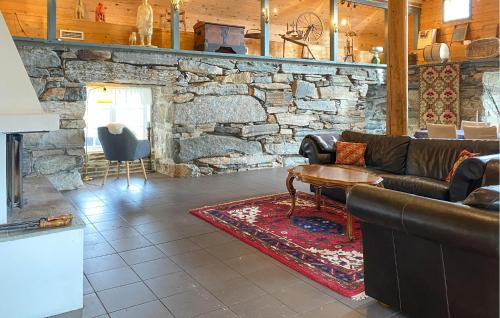 a living room with a couch and a stone wall at Nice Home In Stårheim With Wifi in Stårheim