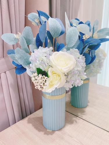 two vases filled with blue and white flowers on a table at 大溪漁港蜜月灣Luna民宿2號館 in Toucheng