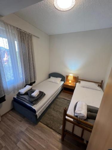 a room with two beds and a window at Milić apartmani 2 in Kuršumlija