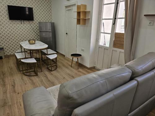 Luxury Apartments Near the Beach and Downtown CENTRUM 8 في أليكانتي: غرفة معيشة مع أريكة وطاولة