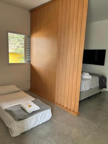 a room with two beds and a television in it at Estúdio ao lado da Praia - Rifaina in Rifaina