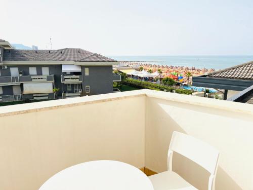 a balcony with a white chair and a view of the ocean at First Line Sea View Apartment Caravella in Silvi Marina