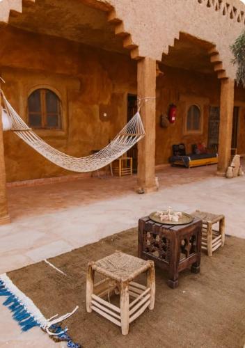 a patio with a hammock in a house at Auberge Itrane in Merzane