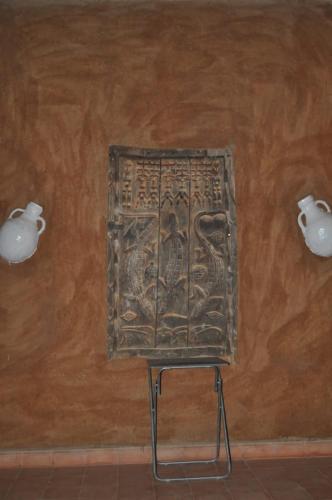 a wall with a metal plaque on a wall at Auberge Itrane in Merzane