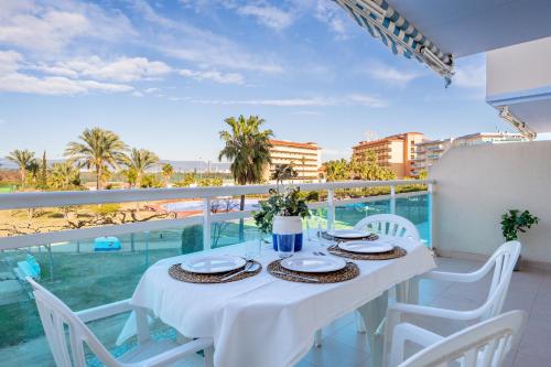 a white table and chairs on a balcony with a view of the ocean at New Juncos 2 Planetcostadorada in La Pineda