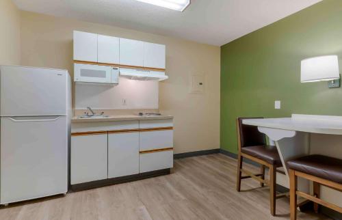 a kitchen with a white refrigerator and a table at Extended Stay America Suites - Fort Worth - Medical Center in Fort Worth