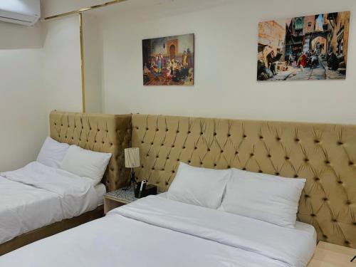 a hotel room with two beds with white pillows at Sunrise Family Big Room in Cairo