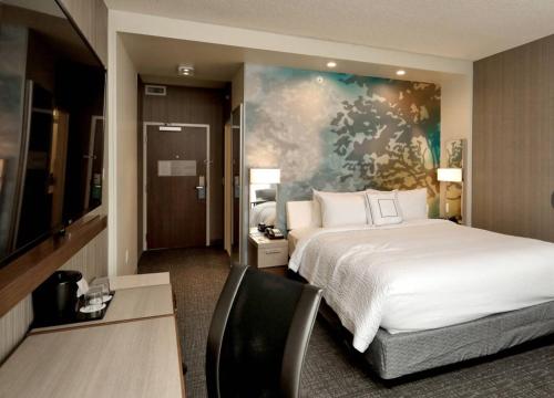 a bedroom with a bed and a desk with a chair at Courtyard by Marriott Deptford in Almonesson