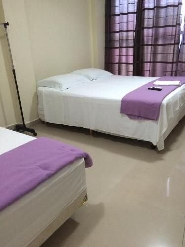 巴西利亞的住宿－Pousada Verdes Flores，紫色床单的客房内的两张床