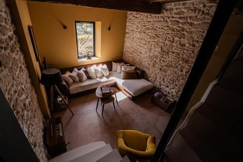 un salon avec un canapé et un mur de briques dans l'établissement Namaste Home, votre havre de paix à St Rémy ! Parking wifi inclus, à Saint-Rémy-de-Provence