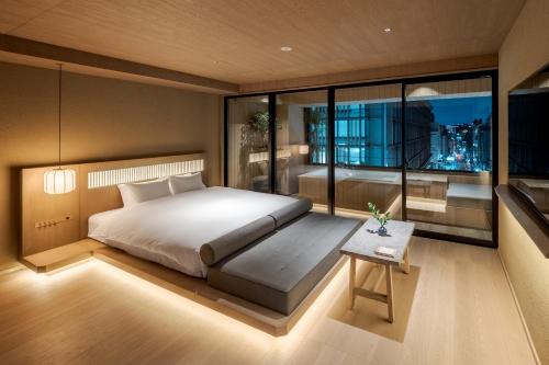 a bedroom with a large bed and a table at MOKU Kyoto in Nishinotōindōri