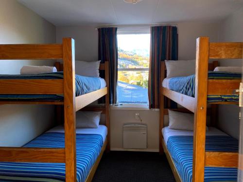 two bunk beds in a room with a window at Pinewood Queenstown in Queenstown