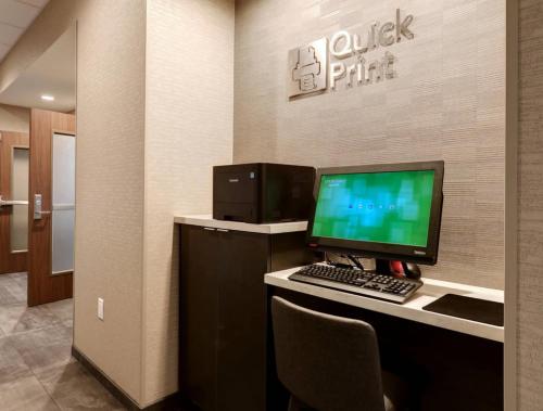a desk with a computer monitor and a keyboard at Courtyard by Marriott Deptford in Almonesson