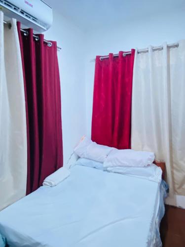 two beds in a room with a red curtain at Chanver Guest House in Babak