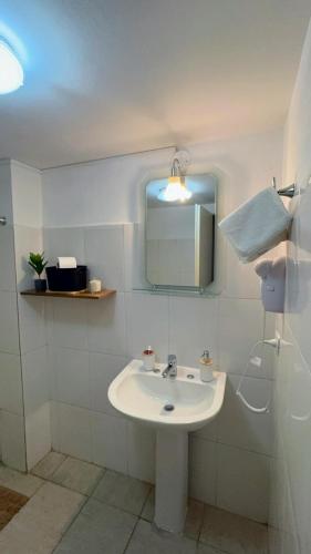 a white bathroom with a sink and a mirror at Depto. PREMIUM Barrio Norte in San Miguel de Tucumán
