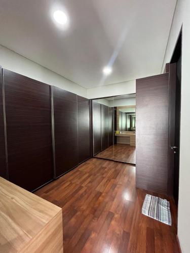 an empty room with wooden cabinets and wood floors at Cipedes Mansion in Bandung