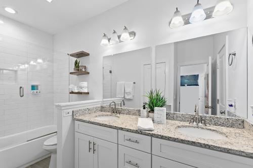 a white bathroom with two sinks and a toilet at Few steps to Ocean-4 Beach Cruisers & Free parking & Private backyard in Jacksonville Beach