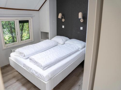 a white bed in a room with a window at Farmhouse in Veluwe near Speulderbos in Ermelo