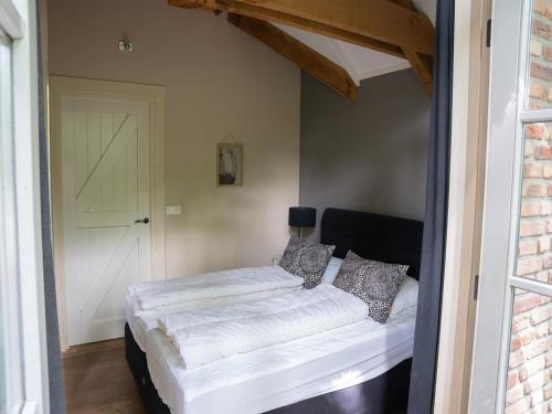 a bedroom with a white bed with pillows on it at Farmhouse in Veluwe with Sauna and Nature Views in Ermelo