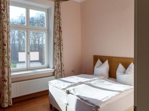 a bedroom with a white bed and a window at Manor Lakeside Escape in Laase