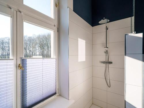 a bathroom with a shower and a window at Manor Lakeside Escape in Laase
