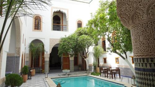 a courtyard of a house with a swimming pool at Riad Sabah in Fès