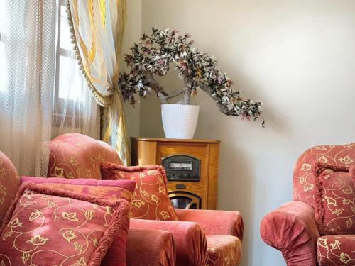 a room with two chairs and a table with a plant at Oranger Family House Marrakech City Center, Private Large House, Terasse Garden View, Free Parking in Marrakech