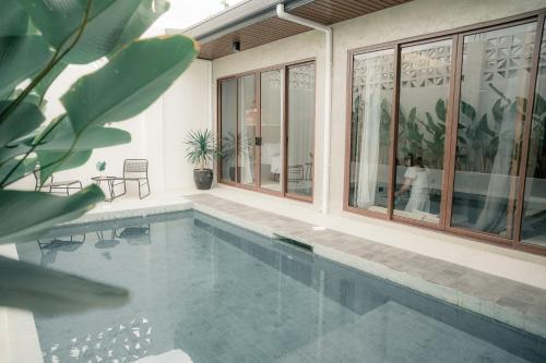 a house with a swimming pool with windows at Balai Mabini in Bantug