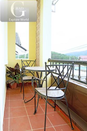 a table and chairs in front of a balcony at Hoang Yen Villa & Coffee in Da Lat
