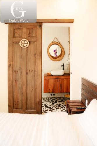 a bathroom with a wooden door and a sink at Hoang Yen Villa & Coffee in Da Lat