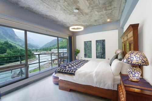 a bedroom with a bed and a large window at Walnut Riverside Resort in Kāgān