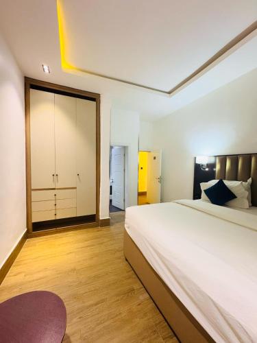 a bedroom with a large bed and a sliding door at Bolton White Residence in Abuja